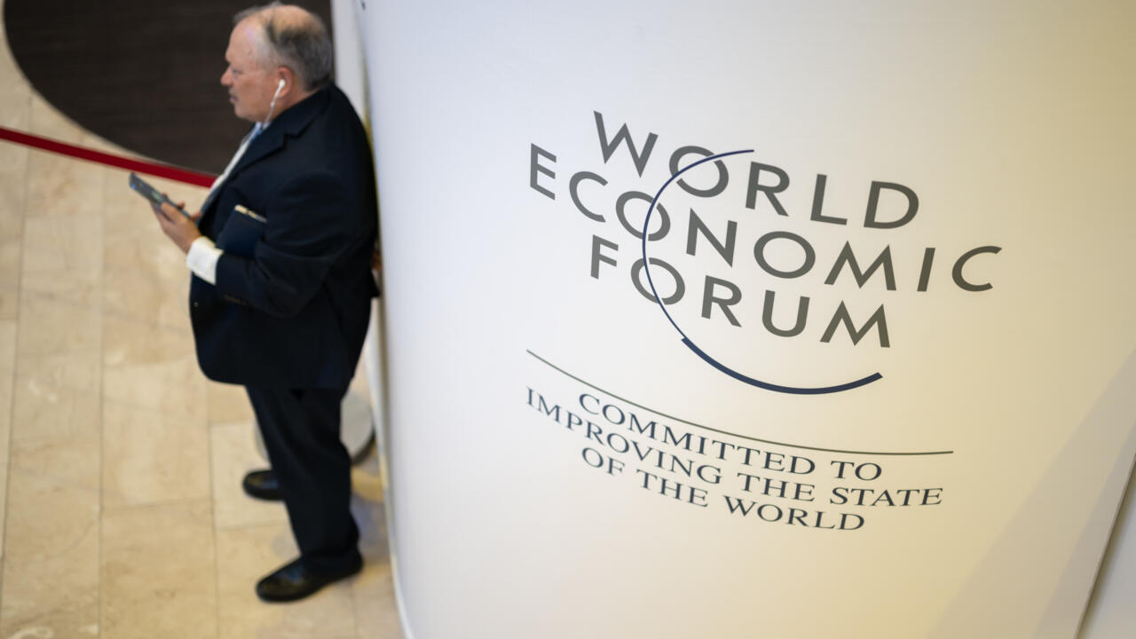 Un participante del Foro Económico Mundial usa su teléfono móvil en el centro de congresos en Davos, Suiza, el 18 de enero de 2023. Foto: AFP.