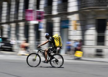 Un repartidor de Glovo pedalea por una calle de Barcelona el 19 de julio de 2022. Foto: AFP.