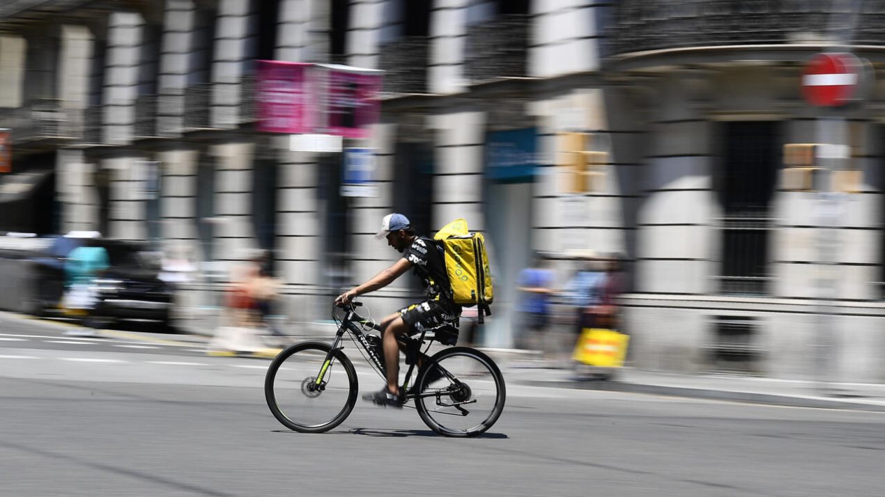 Un repartidor de Glovo pedalea por una calle de Barcelona el 19 de julio de 2022. Foto: AFP.