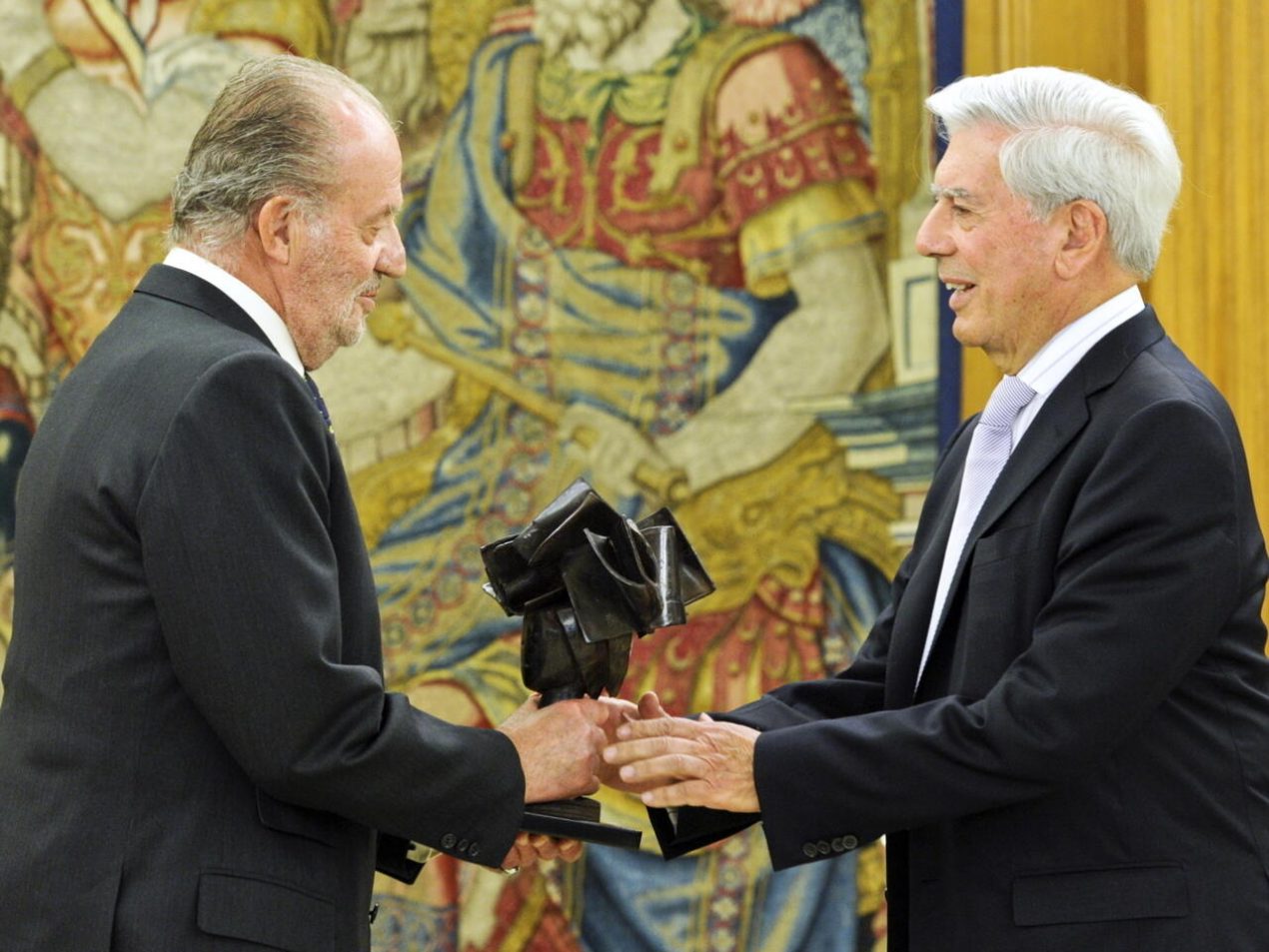 El rey Juan Carlos (izq) entrega una estatuilla de los Premios Don Quijote 2009 al escritor peruano Mario Vargas Llosa en el palacio de la Zarzuela, el 15 de abril del año 2010 en Madrid. Foto: AFP.
