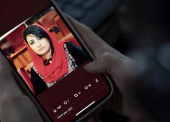 Una mujer afgana ve en su teléfono móvil una imagen de la asesinada Mursal Nabizada el 15 enero de 2023 en Kabul. Foto: AFP.