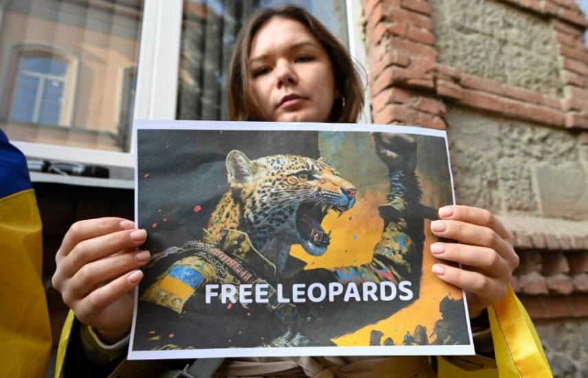 Activista junto a una imagen en apoyo a #FreeTheLeopards. Foto: AFP.