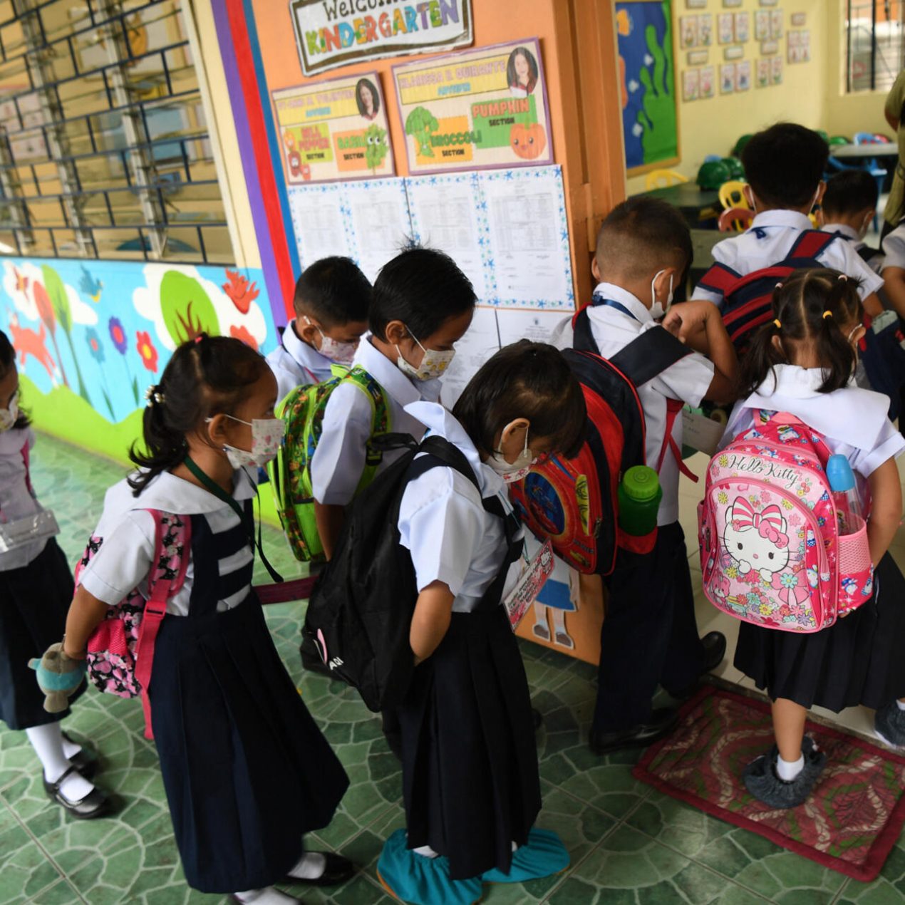 Un grupo de escolares con mascarillas entra en un aula el primer día del curso en Filipinas, el 22 de agosto de 2022 en Quezon City, un suburbio de Manila. Foto: AFP.