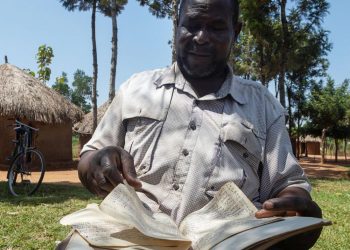 Musa Hasahya Kesera revisa el cuaderno donde anota detalles sobre su extensa familia, el 17 de enero de 2023 en Butaleja, Uganda. Foto: AFP.