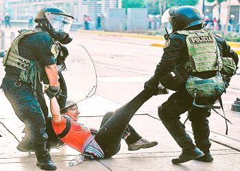 Una manifestante es detenida por dos efectivos de la Policía peruana tras una marcha de protesta.