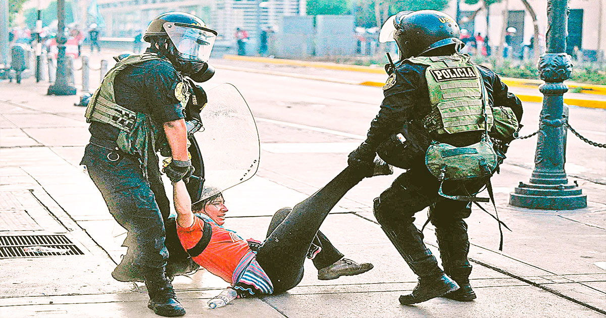 Una manifestante es detenida por dos efectivos de la Policía peruana tras una marcha de protesta.