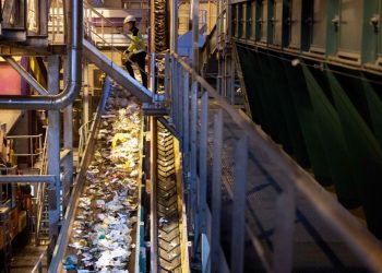Un empleado camina sobre la cinta transportadora para clasificar la basura reciclable en la empresa de gestión de residuos Syctom en París. Foto: AFP.