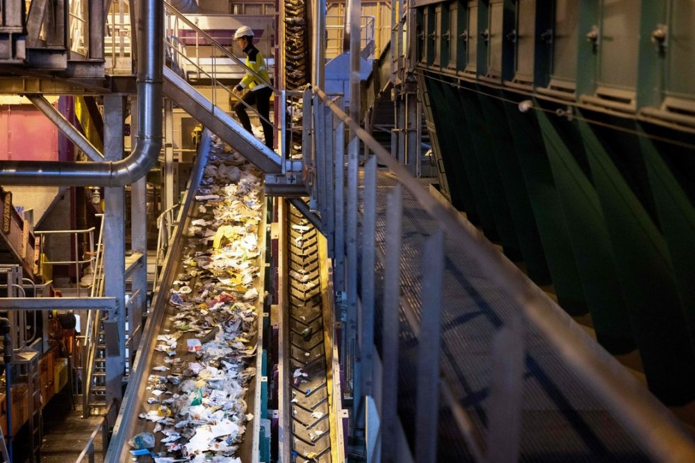 Un empleado camina sobre la cinta transportadora para clasificar la basura reciclable en la empresa de gestión de residuos Syctom en París. Foto: AFP.