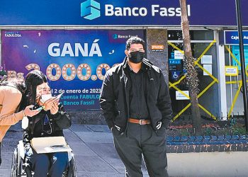 La gente pasa frente a una sucursal del Banco Fassil un día después de la intervención del Gobierno