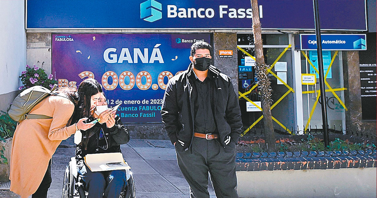La gente pasa frente a una sucursal del Banco Fassil un día después de la intervención del Gobierno