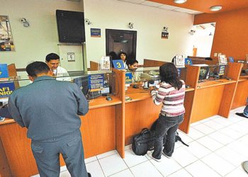Una cliente de una entidad bancaria realiza una transacción en la ciudad de La Paz.