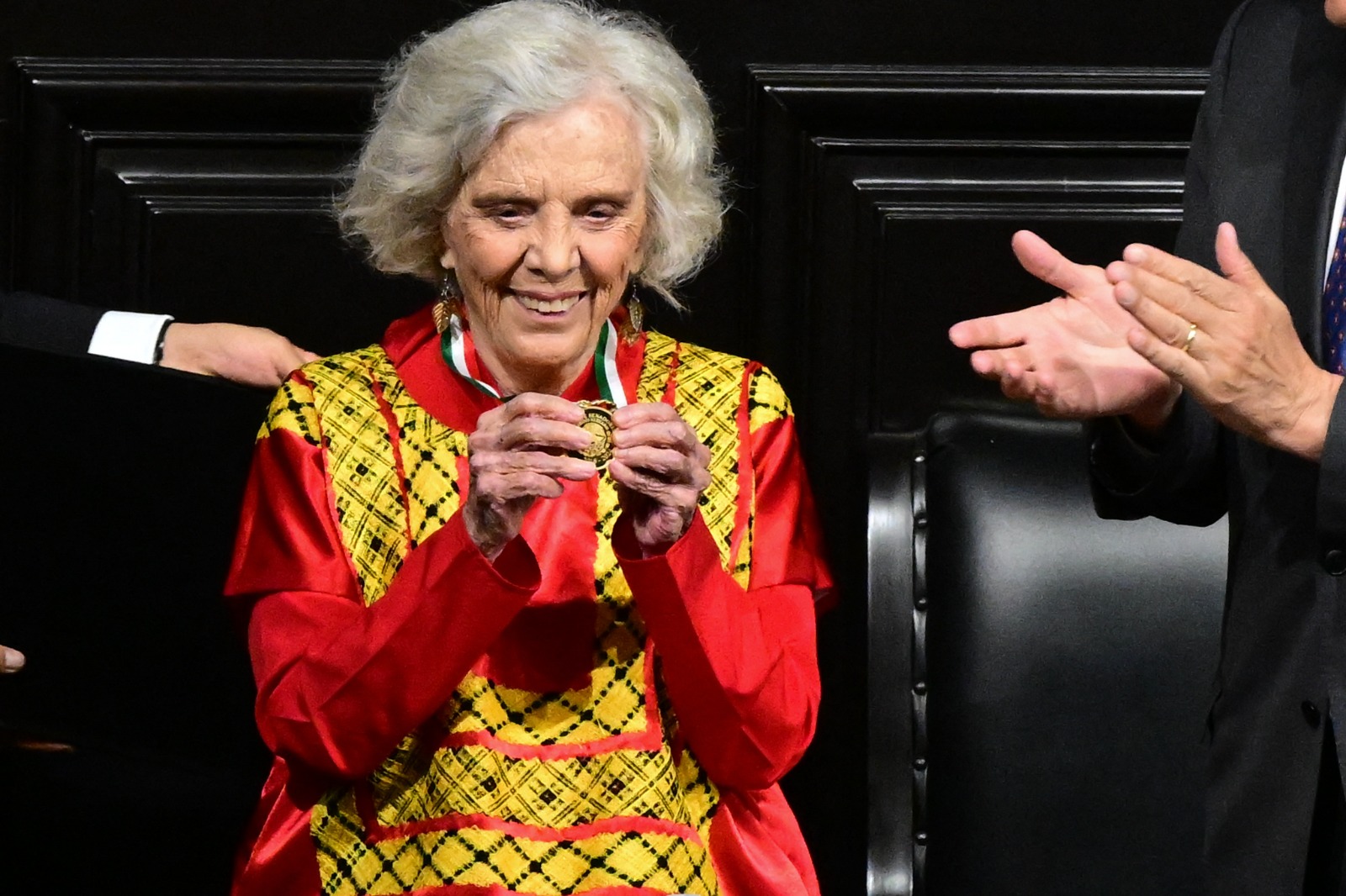 La escritora Elena Poniatowska muestra la medalla que le fue otorgada por su trayectoria. Foto: AFP